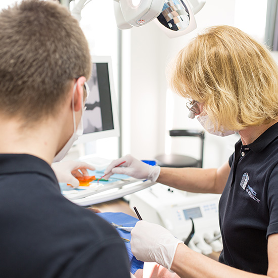 Durchführung einer Implantatprophylaxe der Zahnärztin und eines Assistenten der Zahnärzte im Wengentor in Ulm